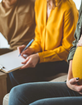 Future parents signing surrogacy agreement with expectant mother